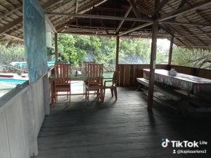 a porch of a house with a table and chairs at Lagoon Homestay in Keruo