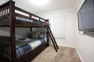 a bedroom with two bunk beds and a window at Sweet 5 Bedroom, 4 Bath Pool Home 1/2 Mile Walk To Disney in Anaheim