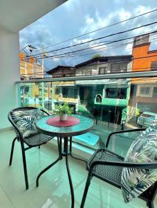 a balcony with a table and two chairs and a window at Apartamento Tranquilo y Acogedor in Sabaneta