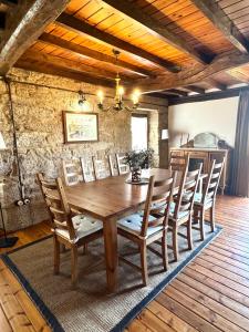a dining room with a wooden table and chairs at A Casa do Ferreiro in Cerdedo