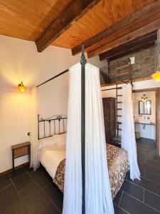 a bedroom with a bed with curtains in a room at A Casa do Ferreiro in Cerdedo