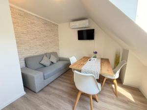 a living room with a table and a couch at Apartments in Green House in Bovec