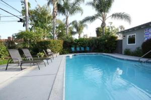 a swimming pool with chairs next to a house at Sweet 5 Bedroom, 4 Bath Pool Home 1/2 Mile Walk To Disney in Anaheim +28 photos