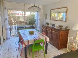 a dining room with a table and green chairs at Agréable Maison basque-Anglet in Anglet