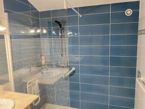 a blue tiled bathroom with a shower and a sink at Agréable Maison basque-Anglet in Anglet +14 photos
