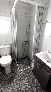 a bathroom with a toilet and a sink at Studios Elpiniki in Skopelos Town +37 photos