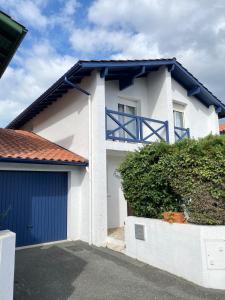 a white and blue house with a blue garage at Agréable Maison basque-Anglet in Anglet