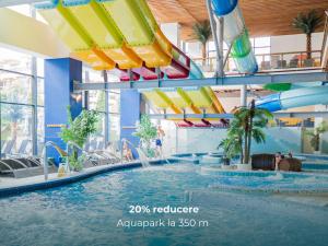 a pool in a mall with a water slide at Hotel Aurora in Băile Olăneşti