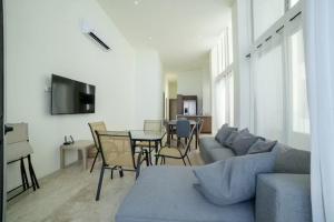 a living room with a couch and a table with chairs at Oceanfront Condo with Pool and Views Telchac | Depto B52 in Xtampú