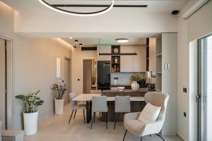 a dining room and kitchen with a table and chairs at Infinity Palm Villa in Stavros