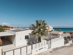 an aerial view of a white house with a palm tree at Infinity Palm Villa in Stavros