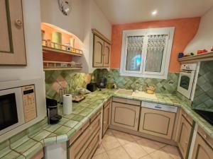 a kitchen with green tiles on the counters at Villa du Capelan - BANDOL in Bandol