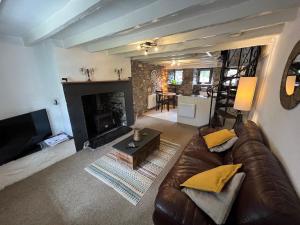 a living room with a couch and a fireplace at Merrion Cottage Penmachno Betws y Coed Conwy in Penmachno