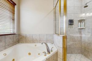 a bathroom with a bath tub and a shower at Scenic Riverfront Home with Boat Access, Private Pool/Hot Tub - Close to Shopping in Lago Vista +29 photos