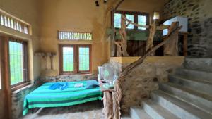 a bedroom with a bed and a stone wall at Achinthya Nature Resort in Avissawella