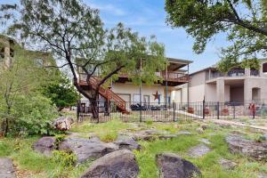 a building with a fence in front of a yard at Scenic Riverfront Home with Boat Access, Private Pool/Hot Tub - Close to Shopping in Lago Vista