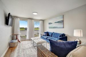 a living room with a blue couch and a tv at Lakeside, Dog-Friendly Living with Kayaks, Boat Ramp, Pool Table & Ping-Pong in Kingsland
