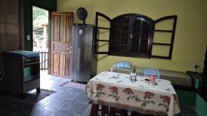 a dining room with a table and a refrigerator at Ouro Grosso Chales in Iporanga