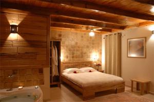 a bedroom with a bed and a bath tub at בקתות באהבה בוטיק in Rosh Pinna