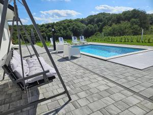a swimming pool with lounge chairs and a swing at Villa Hojnik in Videm pri Ptuju