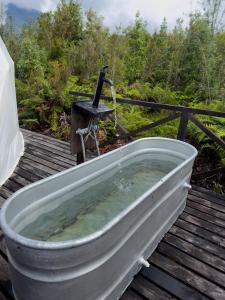 a bath tub sitting on top of a wooden deck at Refugio Volcán Hornopiren in Hornopiren