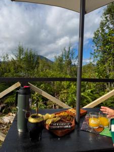 a table with food and drinks on a table with a view at Refugio Volcán Hornopiren in Hornopiren