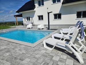 a swimming pool with two lounge chairs and a swimming pool at Villa Hojnik in Videm pri Ptuju