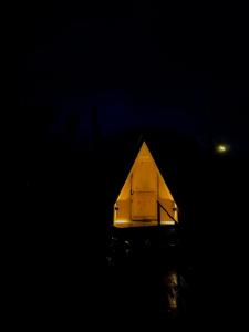 a tent is lit up in the dark at Refugio Volcán Hornopiren in Hornopiren