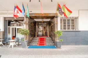 a red carpet at the entrance to a building with flags at Hôtel Mauritania Centre-Ville Casablanca Petit-Déjeuner Buffet Gratuit in Casablanca