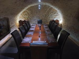 a long table with black chairs and a room with a long table at Auberge de la vallee de la gorre in Saint-Auvent