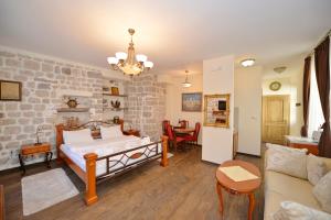 ein Schlafzimmer mit einem Bett und einer Ziegelwand in der Unterkunft Palazzo Max and Alex Apartments in Kotor