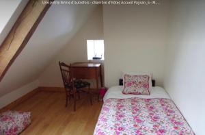 a small bedroom with a bed and a desk at La Petite Ferme d'Autrefois in Saint-Georges-Nigremont