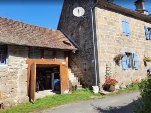 an old stone building with an open door at La Petite Ferme d'Autrefois in Saint-Georges-Nigremont