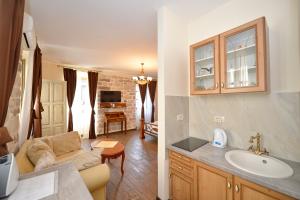 ein Badezimmer mit einem Waschbecken und ein Wohnzimmer in der Unterkunft Palazzo Max and Alex Apartments in Kotor + 111 Fotos