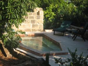 a swimming pool with a chair and a bench on a patio at בקתות באהבה בוטיק in Rosh Pinna