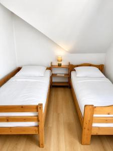 two beds in a small room with wooden floors at APARTMENT ON THE ROAD S-61 in Szypliszki
