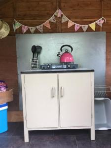 a white cabinet with a tea pot on top of it at Cefn Crib Safari Tent in Machynlleth +9 photos