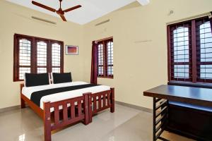 a bedroom with a bed and a piano at Hotel O Nakshathra Inn in Kazhakuttam