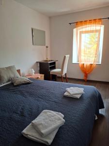 a bedroom with a bed with two towels on it at Kameni biser in Jurdani