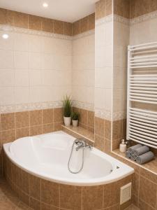 a bath tub in a tiled bathroom at APARTMENT ON THE ROAD S-61 in Szypliszki