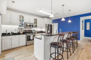 a kitchen with white cabinets and bar stools at SBC1001 - Sweet Retreat in Manteo +46 photos