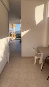 ein Esszimmer mit Tisch und Stühlen und einem Balkon in der Unterkunft Marathi Panorama Rooms in Marathi
