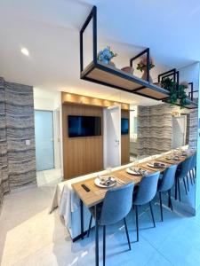 a dining room with a long table and chairs at Infinity 1206 - 2 Quartos a Passos da Praia com Garagem in Vila Velha