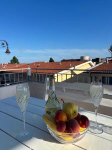 two wine glasses and a bowl of fruit on a table at Апартамент Енигма in Sveti Vlas +7 photos