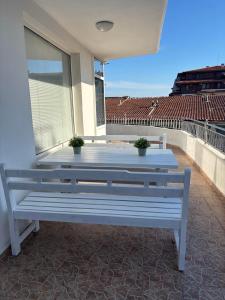 a white bench sitting on top of a balcony at Апартамент Енигма in Sveti Vlas
