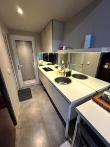 a large kitchen with two sinks and a counter at Comfortable House - Tabebuya BSD in Tegal