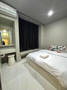 a bedroom with a bed and a sink and a mirror at Comfortable House - Tabebuya BSD in Tegal
