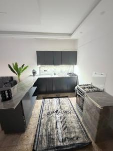 a kitchen with black cabinets and a counter top at Neue renovierte Wohnung mit Meerblick und große Balkon in tripoli ,Qalamoun in El Qalmoûn