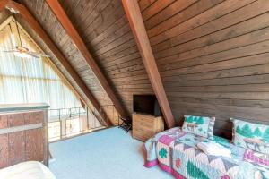 a attic room with a bed and a tv at Charming, lakefront A-frame with private dock, lakeside gazebo, spacious deck in Bumpass