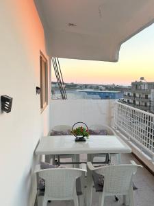 a table and chairs on a balcony with a view at Neue renovierte Wohnung mit Meerblick und große Balkon in tripoli ,Qalamoun in El Qalmoûn